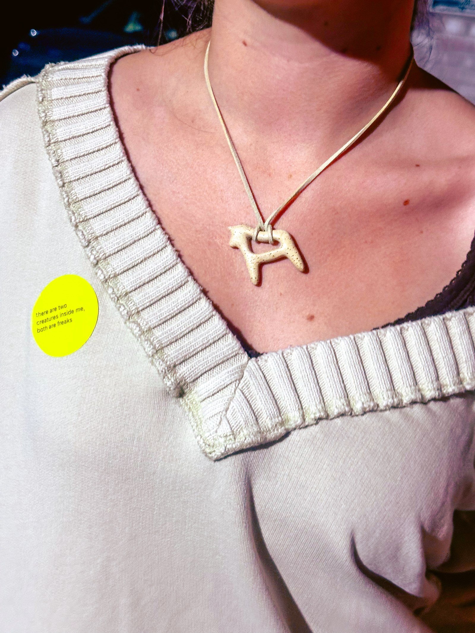 Person wearing a handmade ceramic horse pendant necklace